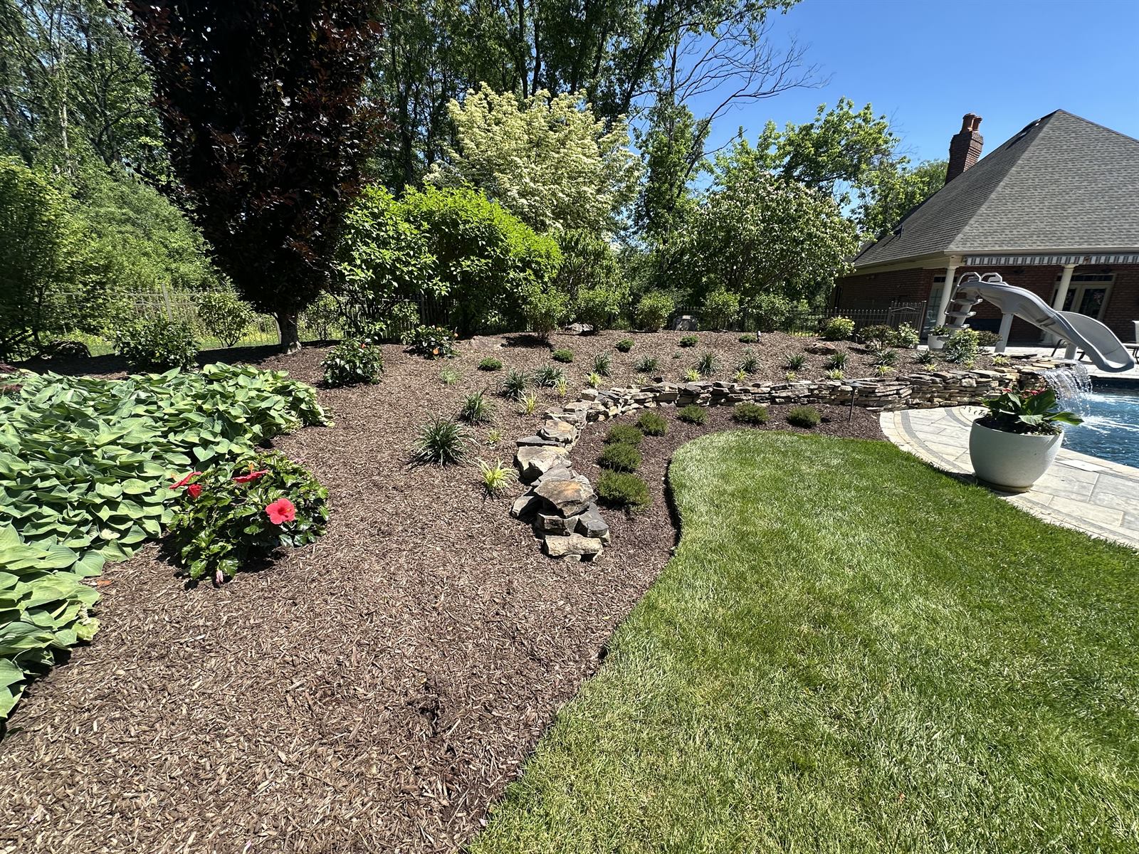 Manicured suburban landscape with dense ornamental beds in a Central PA neighborhood — the kind of property where mosquito barrier treatments deliver the best results