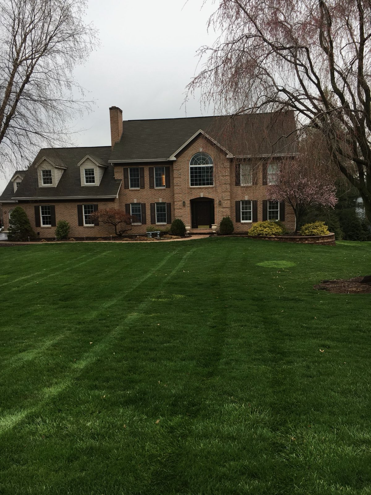 Freshly mowed lawn in front of a brick home in Central PA